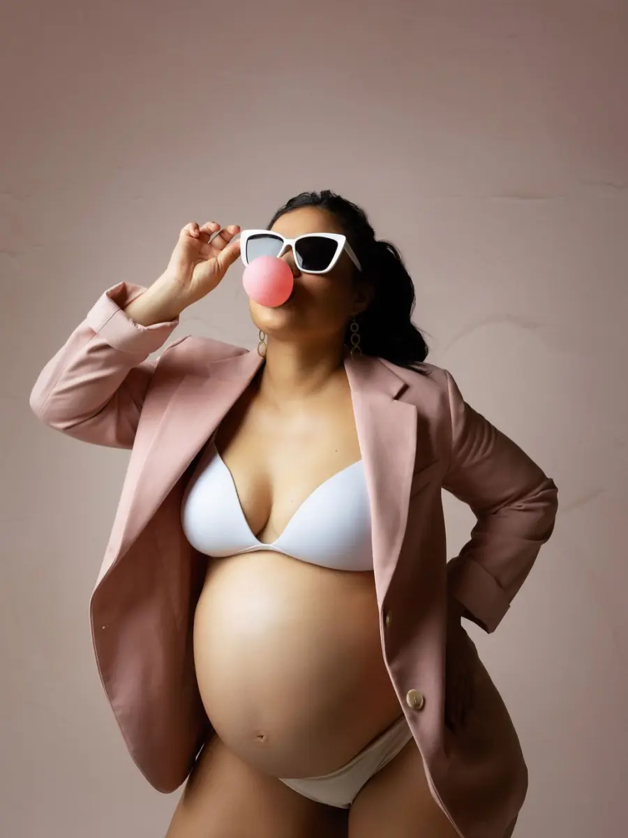 Sesión de maternidad con chaqueta rosada, gafas de sol y bomba de chicle