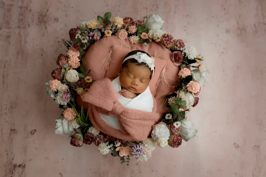 Recién nacida dormida dentro de una corona de flores